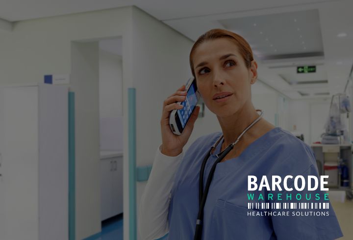 Healthcare professional holding connectivity mobile device to ear in a hospital setting